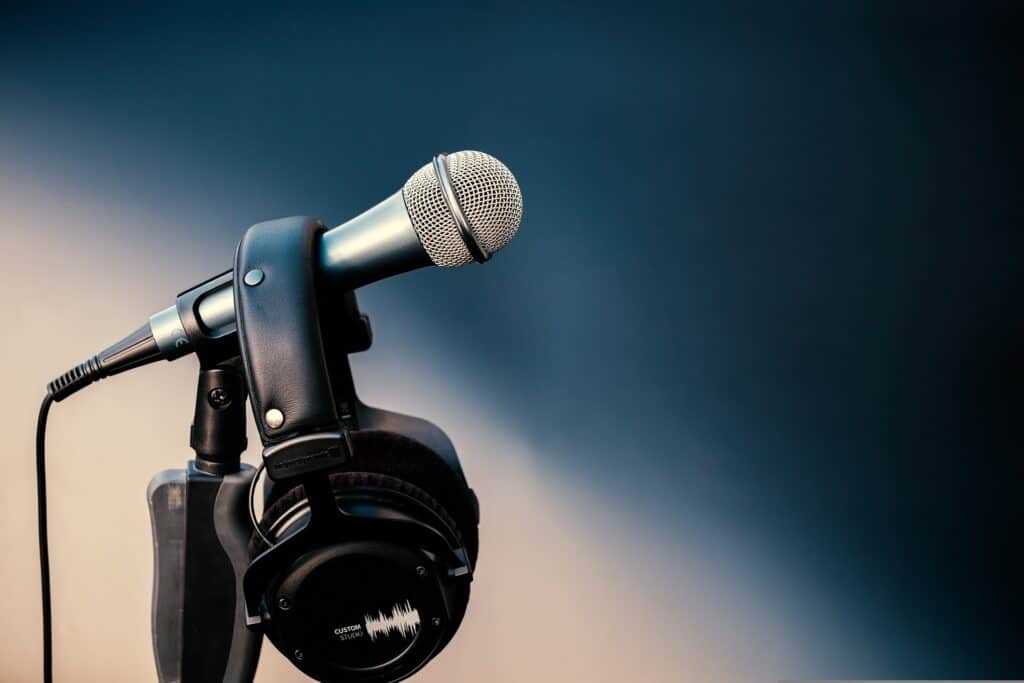 Mikrofon mit Kopfhörern vor grauem Hintergrund – Sprechertexte 