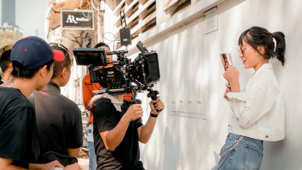 Werbevideo erstellen auf der Straße: Filmcrew filmt Frau am Handy