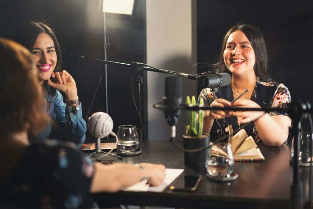 Drei Frauen an einem Tisch bei der Podcast Aufnahme mit AI Video Tools